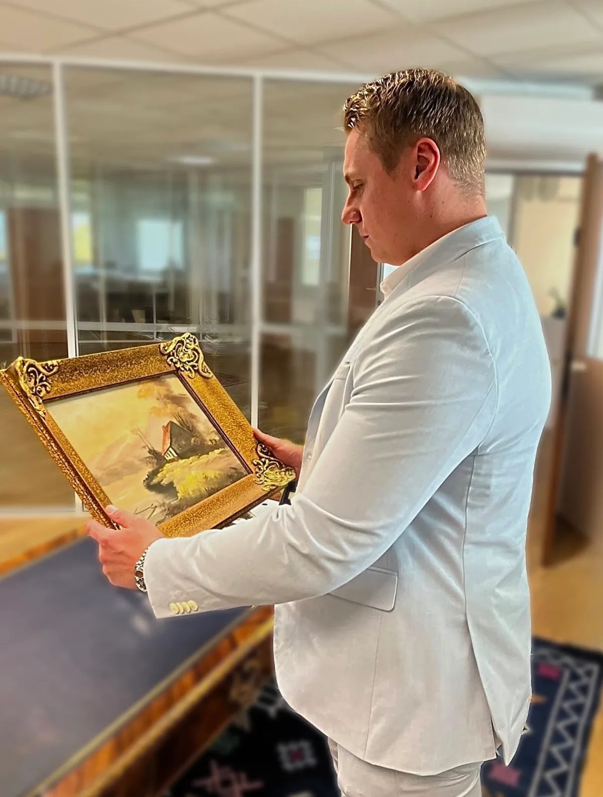 Florian, expert de l'équipe, examine une peinture ancienne dans son cadre doré, à Marrakech