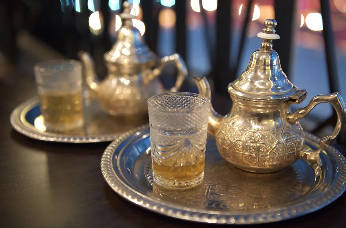 Théières marocaines en métal argenté ciselé sur plateaux, verres à thé : argenterie estimée et rachetée au Maroc